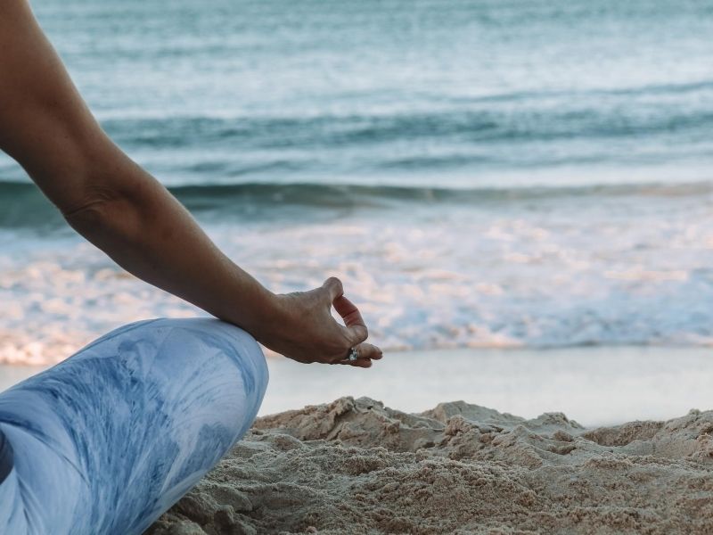 Woman on beach doing yoga