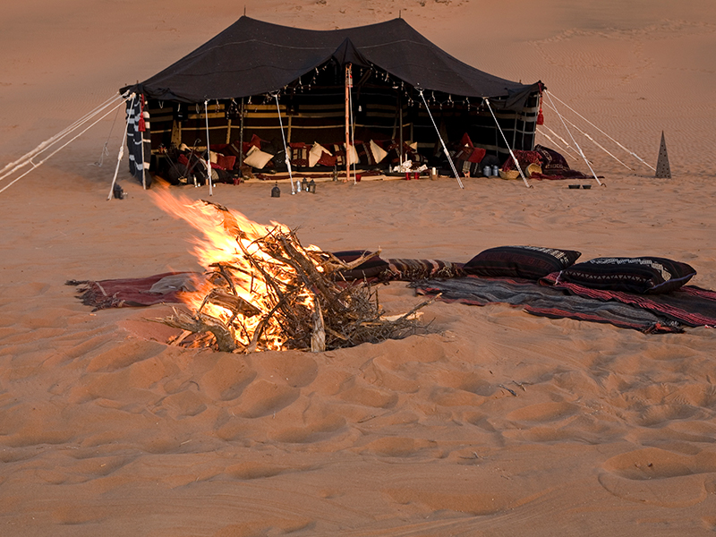Dine by the campfire during your desert stay on luxury holidays to Oman